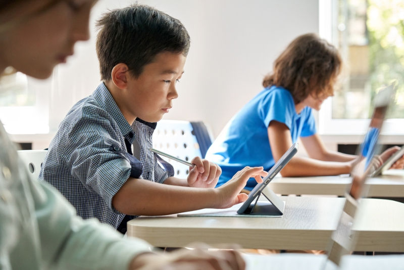 A young student accessing an AI tool on their school tablet