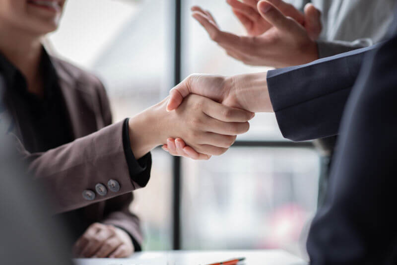 two people shaking hands in a business meeting