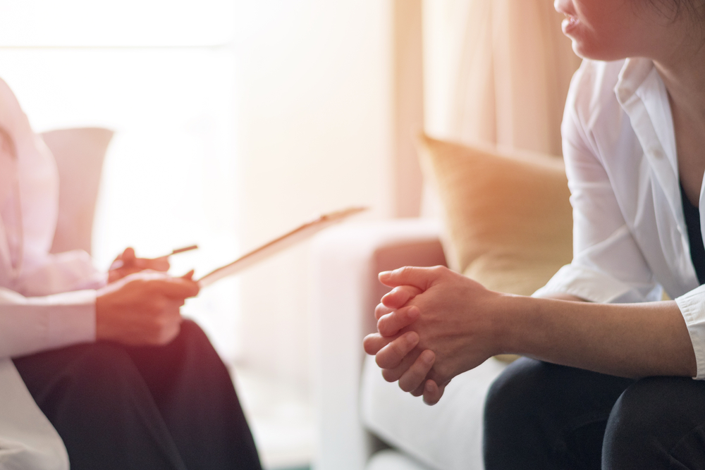 a PMHNP consulting with a patient in a sunny hospital