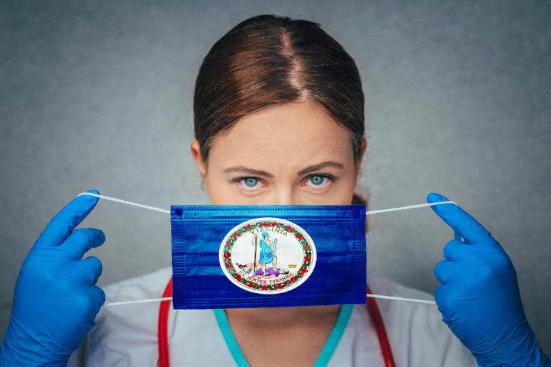 A nurse covering her face with the Virginia logo on it