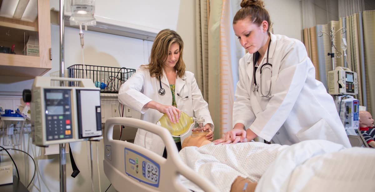 Nurse students practicing holistic care with a dummy patient