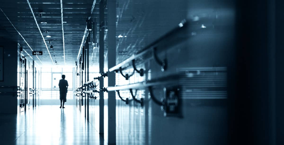 Nurse walking down dark hospital corridor