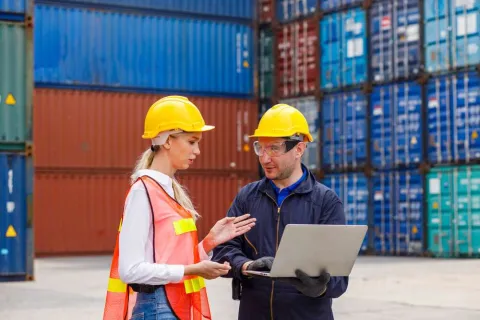 Dock workers consulting with an AI solution designed to help with supply chain management