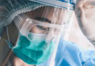 A nurse wearing a face mask and shield